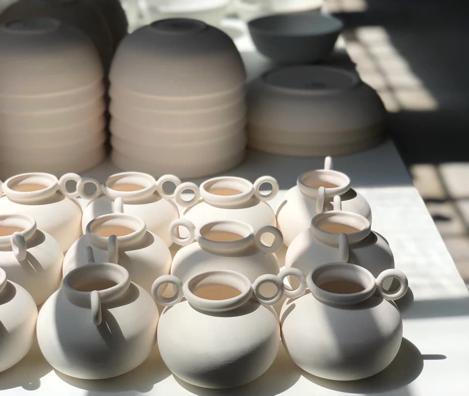 Hands pulling clay on a wheel in the Luvhaus studio in West Oakland